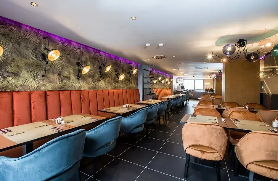 Comedor del hotel con bancos tapizados y luces de colores