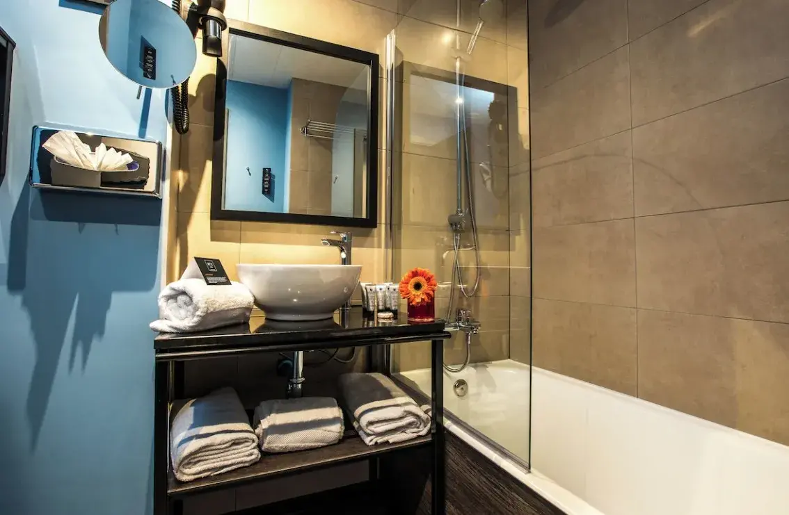 Baño con bañera y lavabo sobre encimera