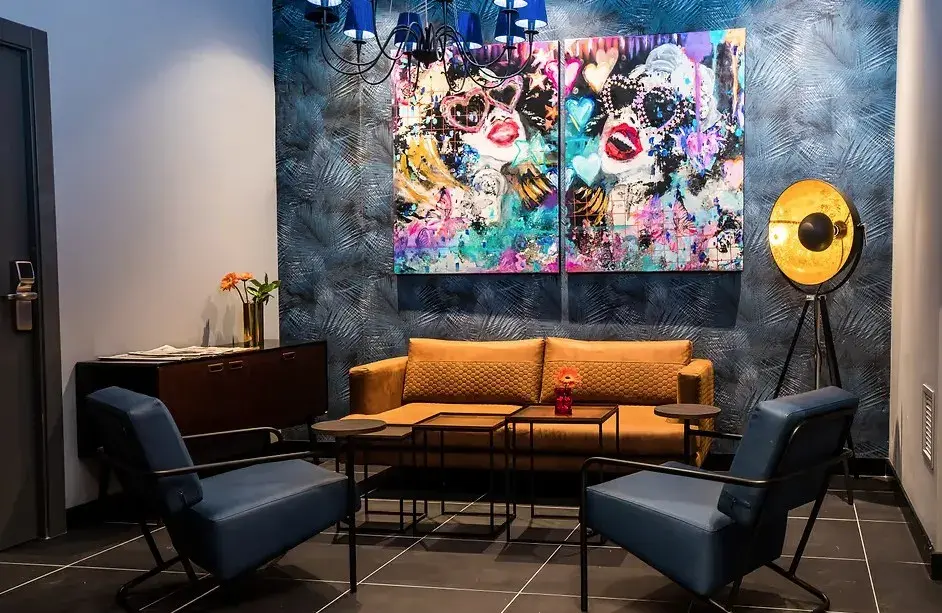 Sofá naranja y arte urbano en una zona de estar del hotel